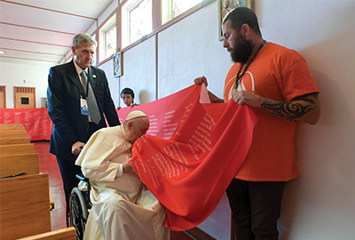 Pope Francis blesses a banner with the names of school children who died in Edmonton, Canada.